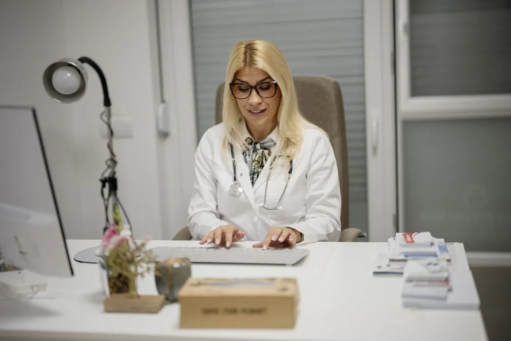 Doctora toma notas durante la consulta con un paciente