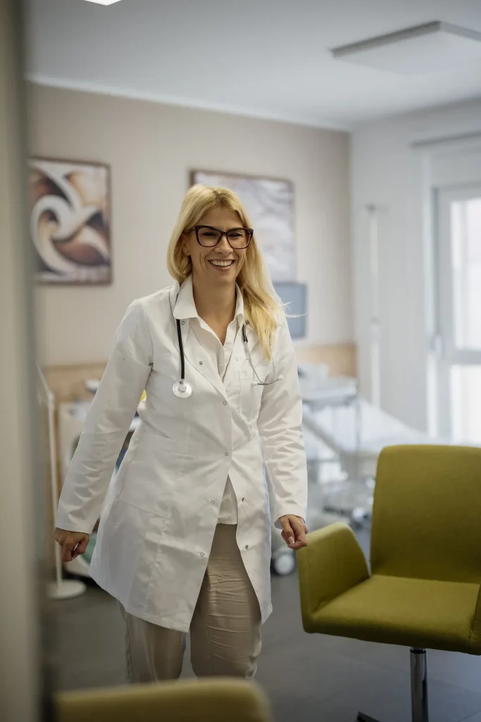 Doctora con bata blanca entrando a un consultorio luminoso